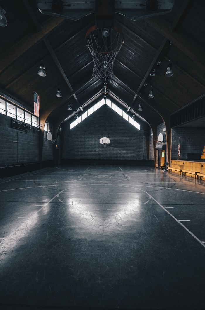 A dimly lit, empty basketball court with modern architecture in Chicago.